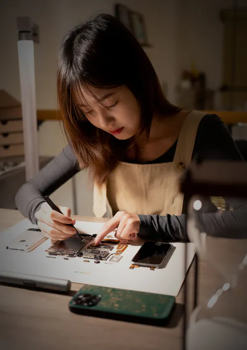 Technician replacing a smartphone battery in repair workshop